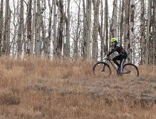 Skyline high school mountain bike team member rides in the mountains during the fall