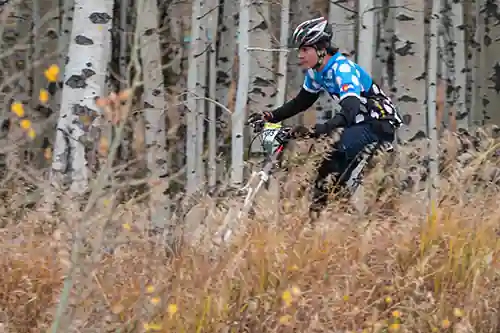 Lyons high school mountain bike rider descending by fall colors at Granby Ranch